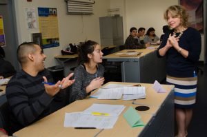 Professor engaging with two students in classroom