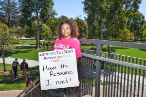 Palomar Student holding a sign that reads- Because you give I can have the resources I need