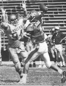 Black and white newspaper photo of football players during a game