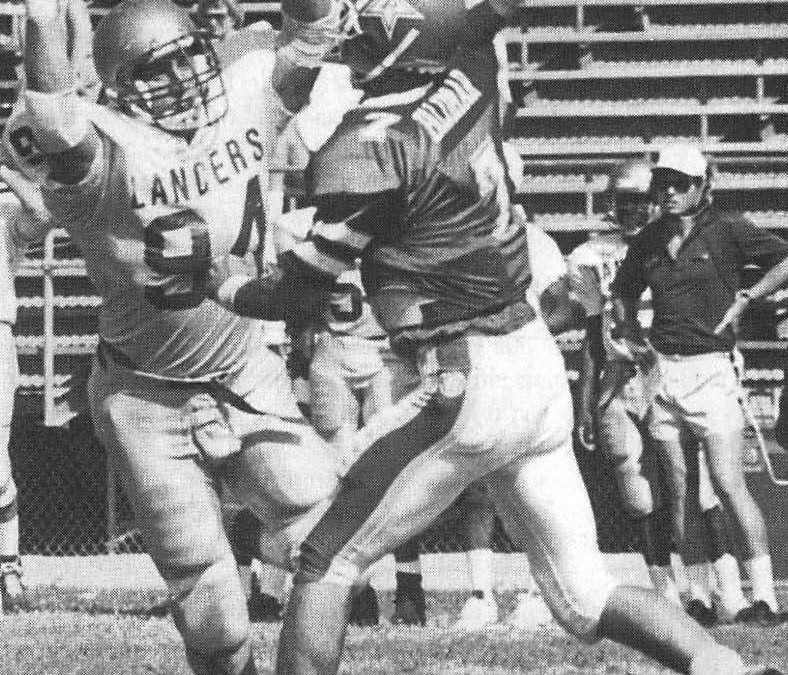 Black and white newspaper photo of football players during a game