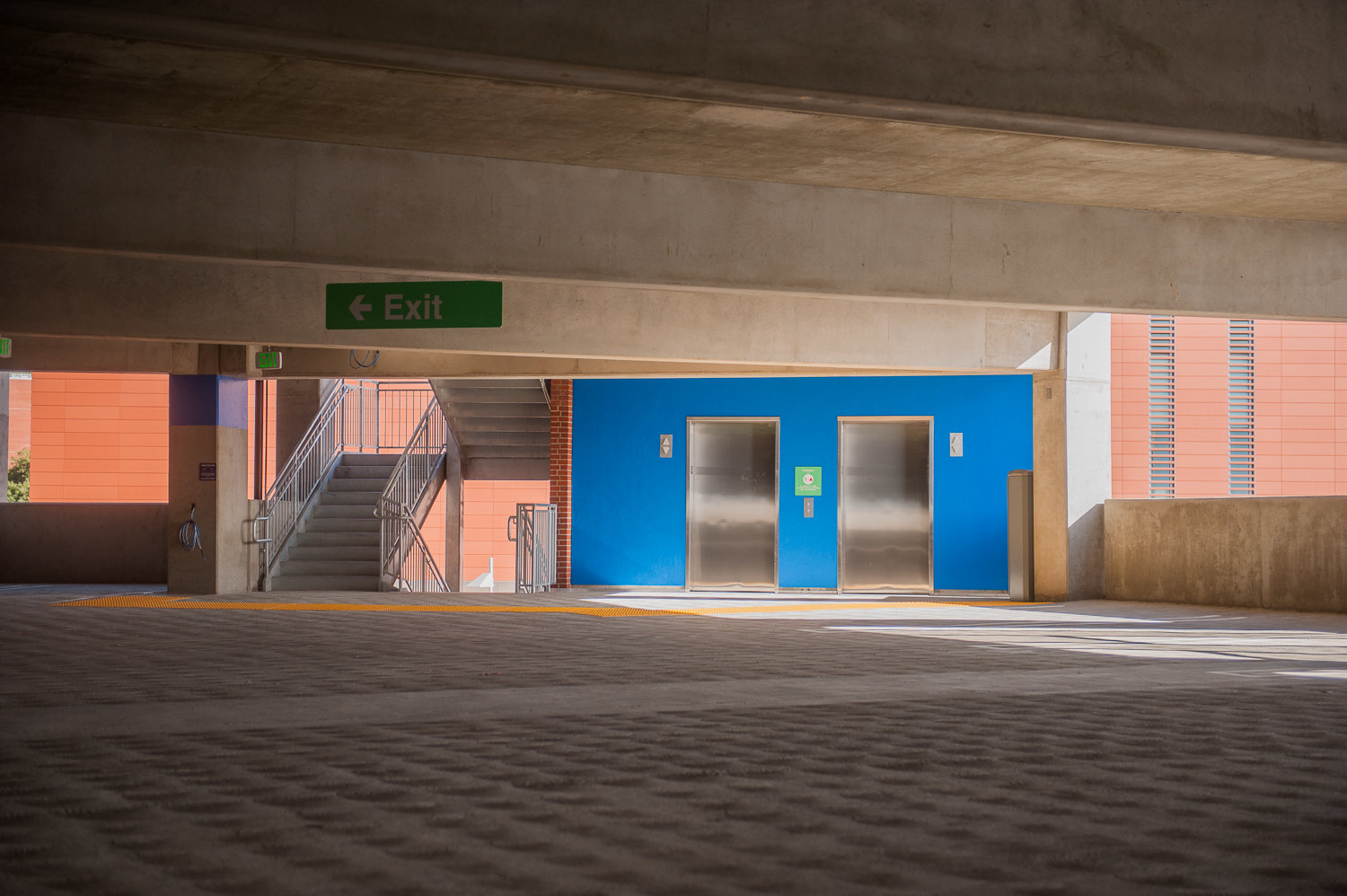 View of elevator doors and stairwell inside parking garage