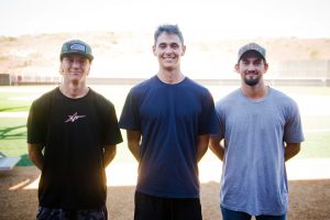 Three Comet baseball players standing on field