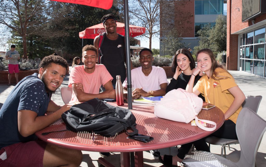 Students sitting at a table outside on campus