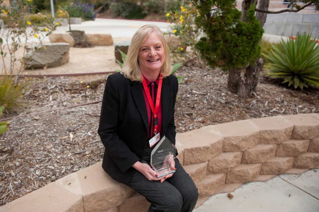 Student Health Director Judy Harris holding an award