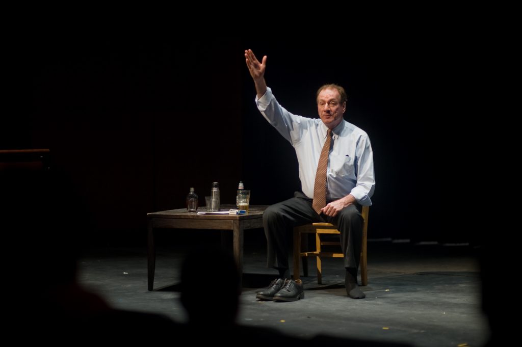 Actor on stage performing his one-man show
