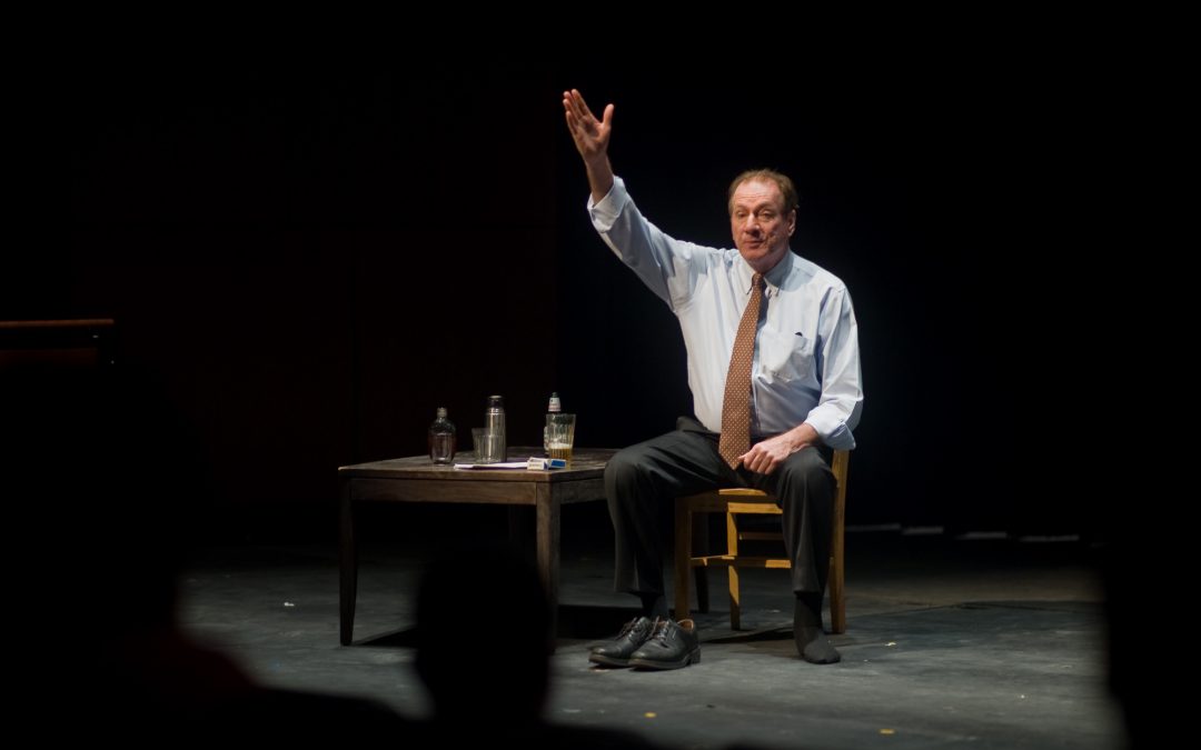 Actor on stage performing his one-man show