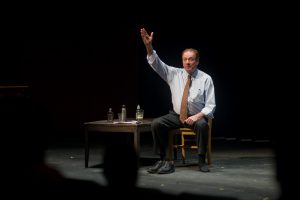 Actor on stage performing his one-man show