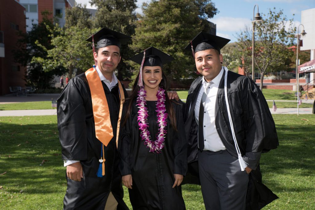 Group of three grads in caps and gowns