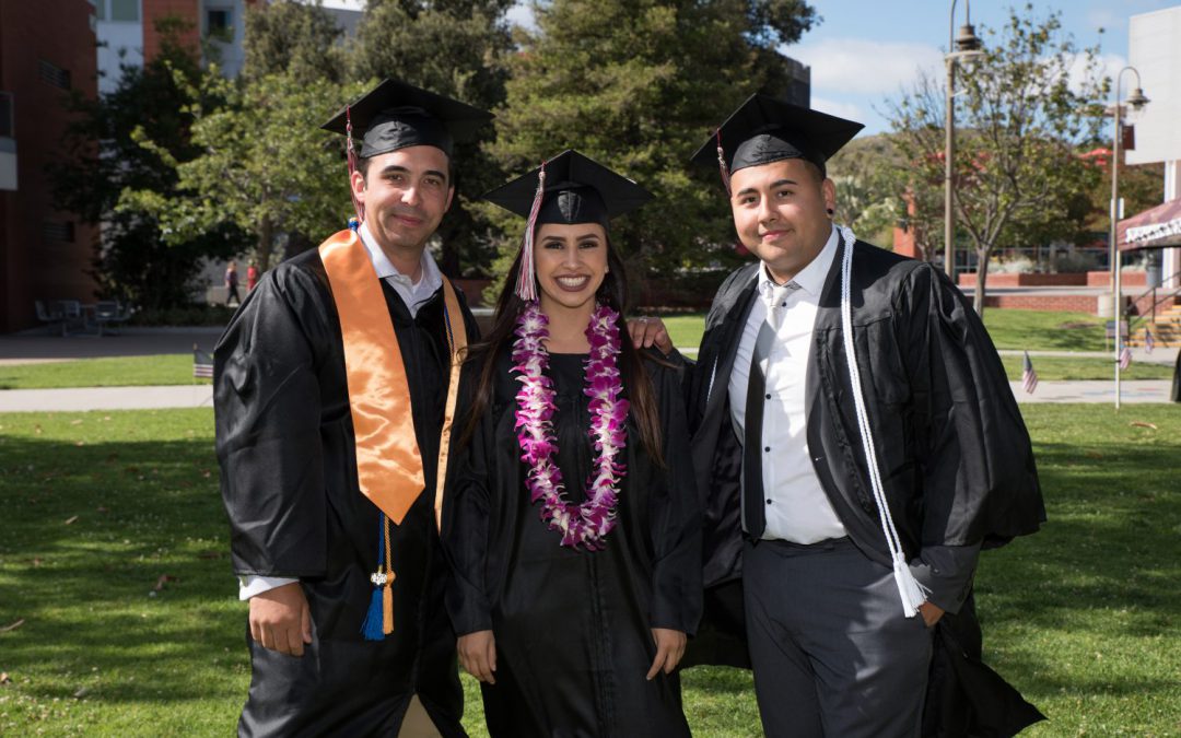 Group of three grads in caps and gowns