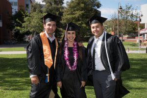 Group of three grads in caps and gowns