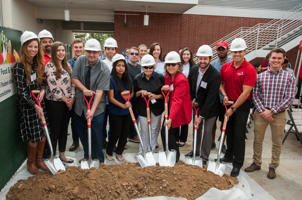 Group of Palomar leadership, staff and guests holding shovels and breaking ground