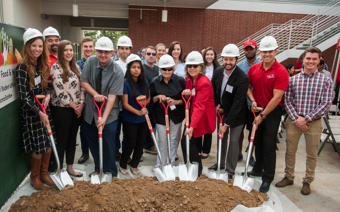 Group of Palomar leadership, staff and guests holding shovels and breaking ground