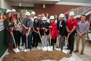 Group of Palomar leadership, staff and guests holding shovels and breaking ground