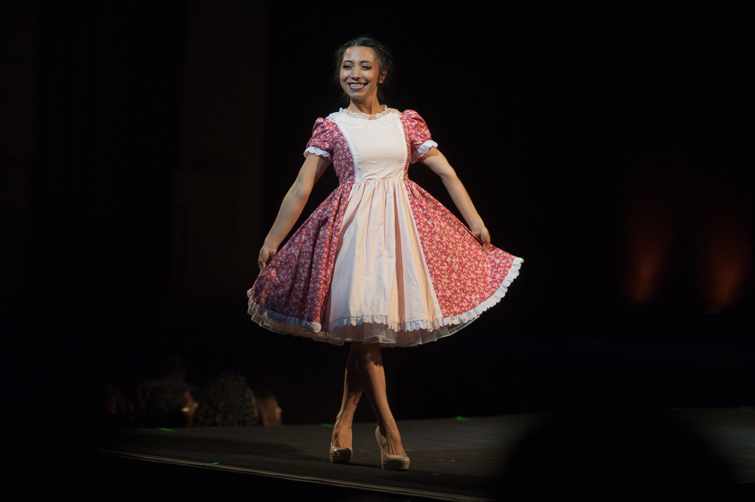 Female model walking runway in a floral dress