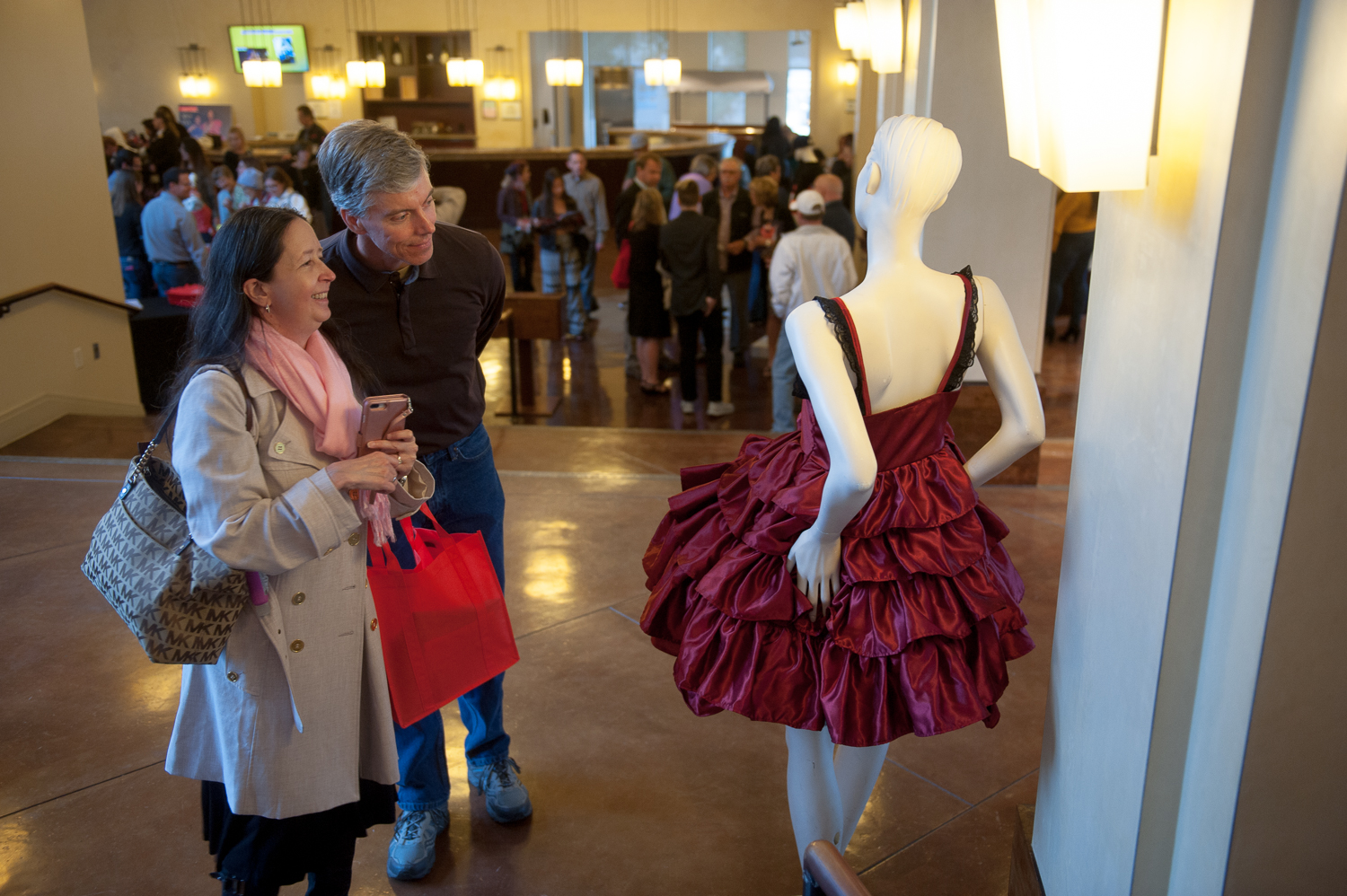 Visitors admiring student fashion designer clothing in the lobby