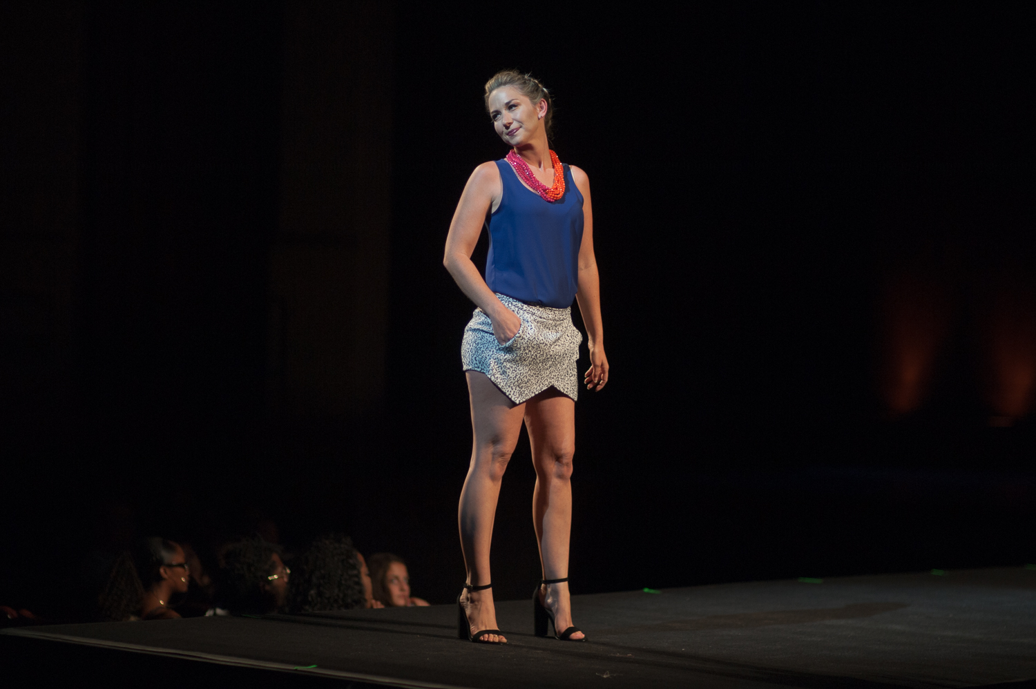Female model posing on runway wearing a leopard skirt