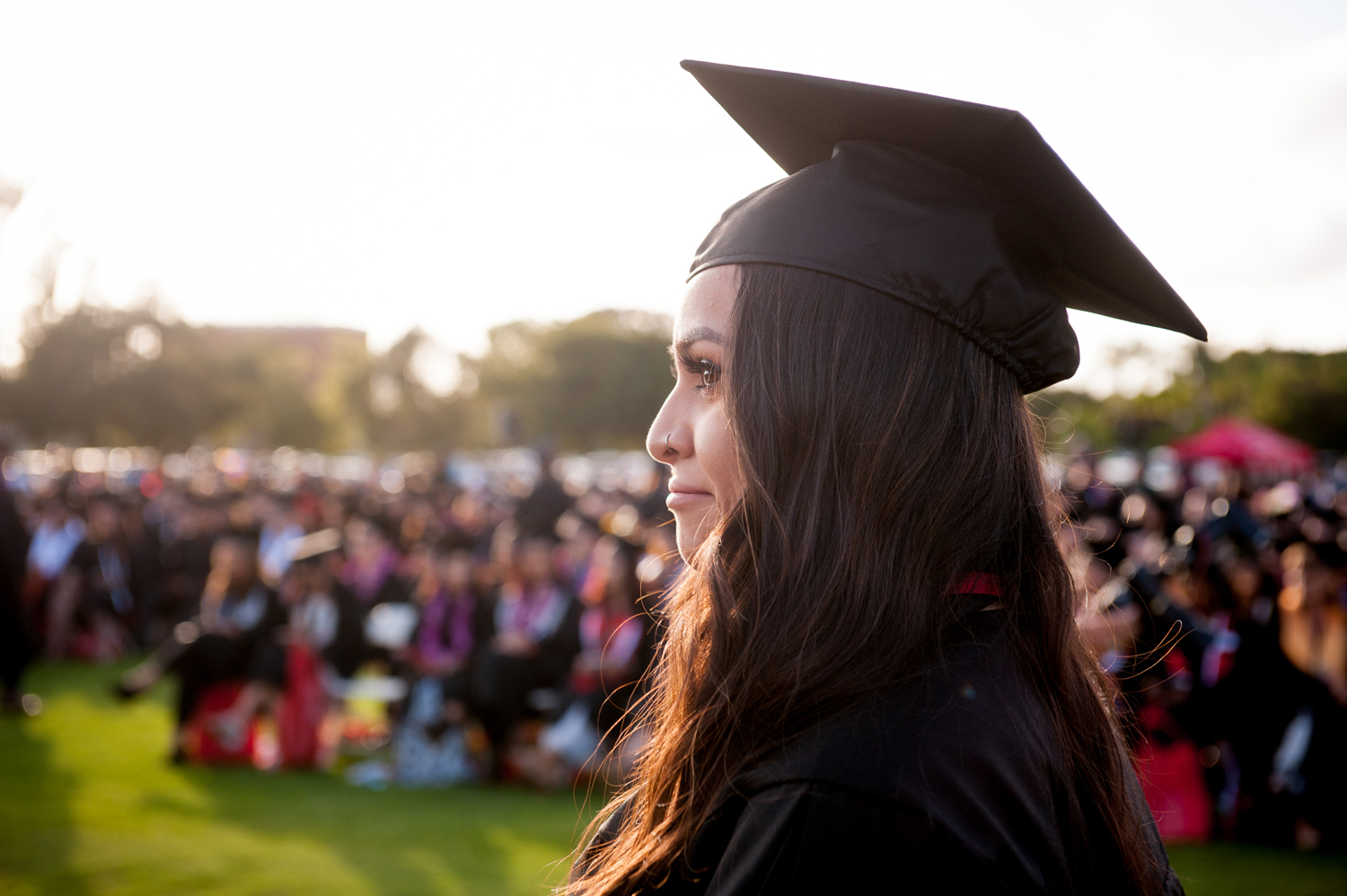 Female graduate in cap and gown at commencement ceremony