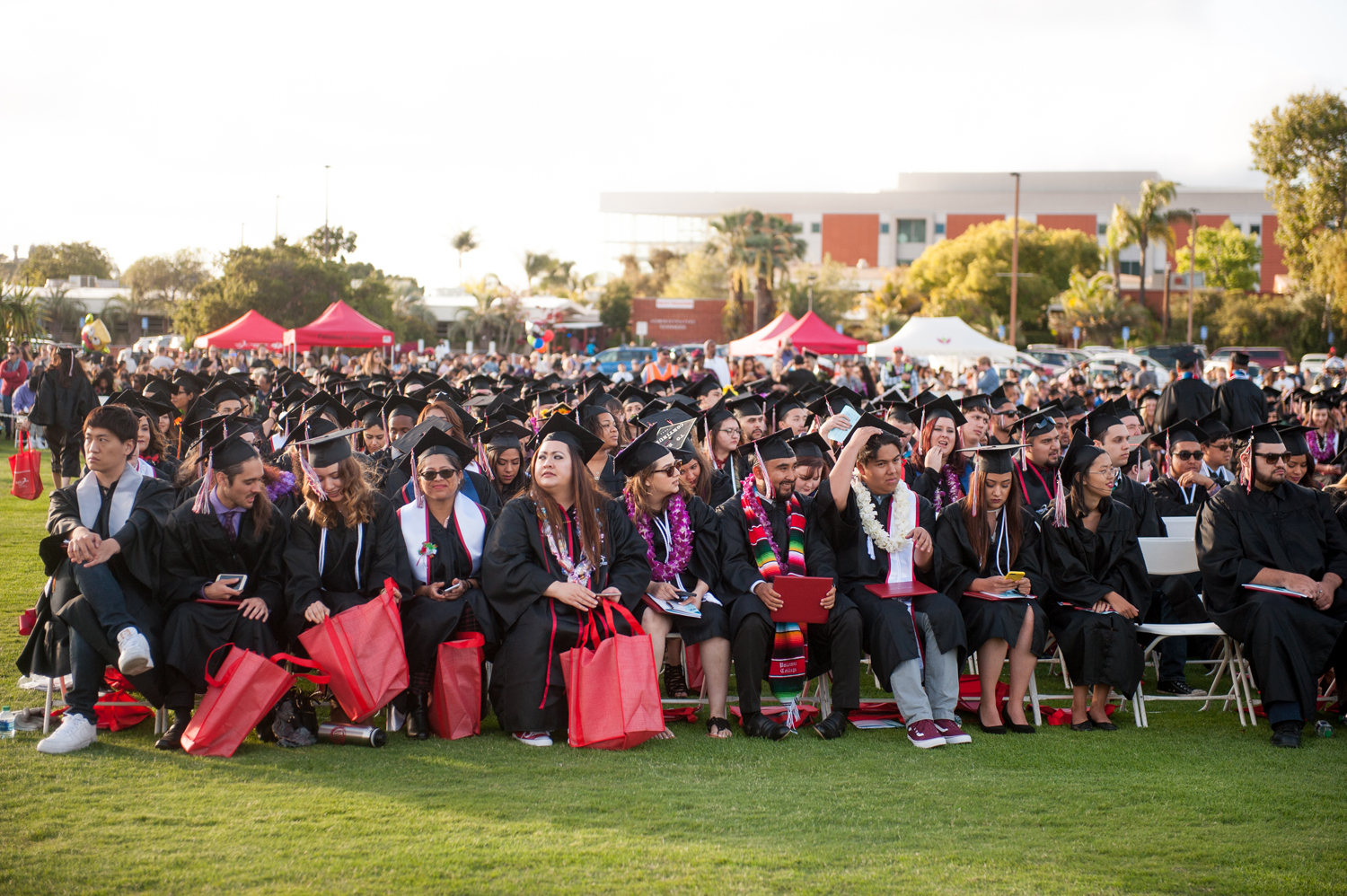 Graduates sitting in chairs on the lawn outside at commencement