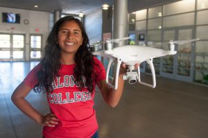 Drone student wearing a red Palomar College shirt and holding drone