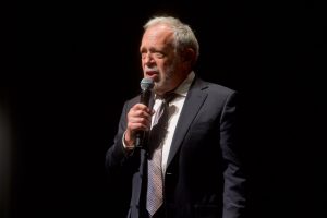 Robert Reich holding microphone