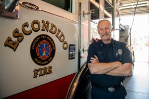 Fire captain in uniform standing next to an Escondido Fire truck