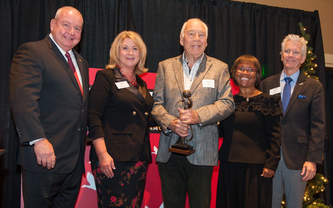 Palomar leadership, staff and guests standing with the 2018 Comet Award recipient holding his award