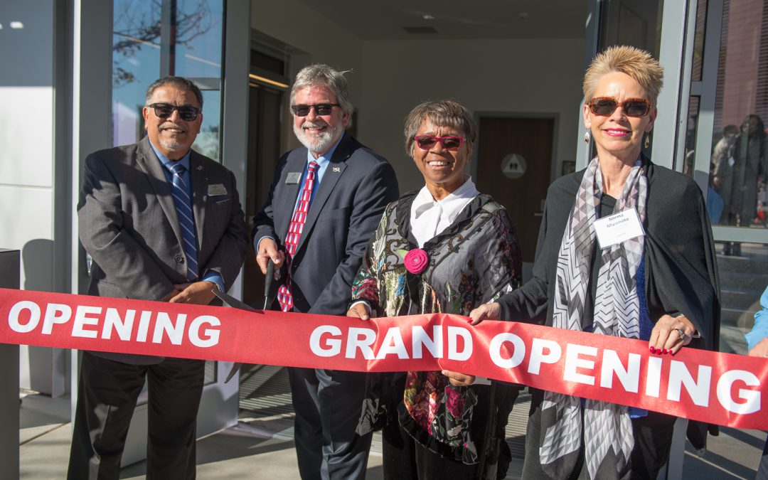 Palomar leadership and staff cutting a red ribbon in front of the police building
