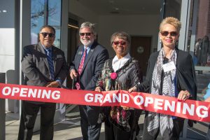 Palomar leadership and staff cutting a red ribbon in front of the police building