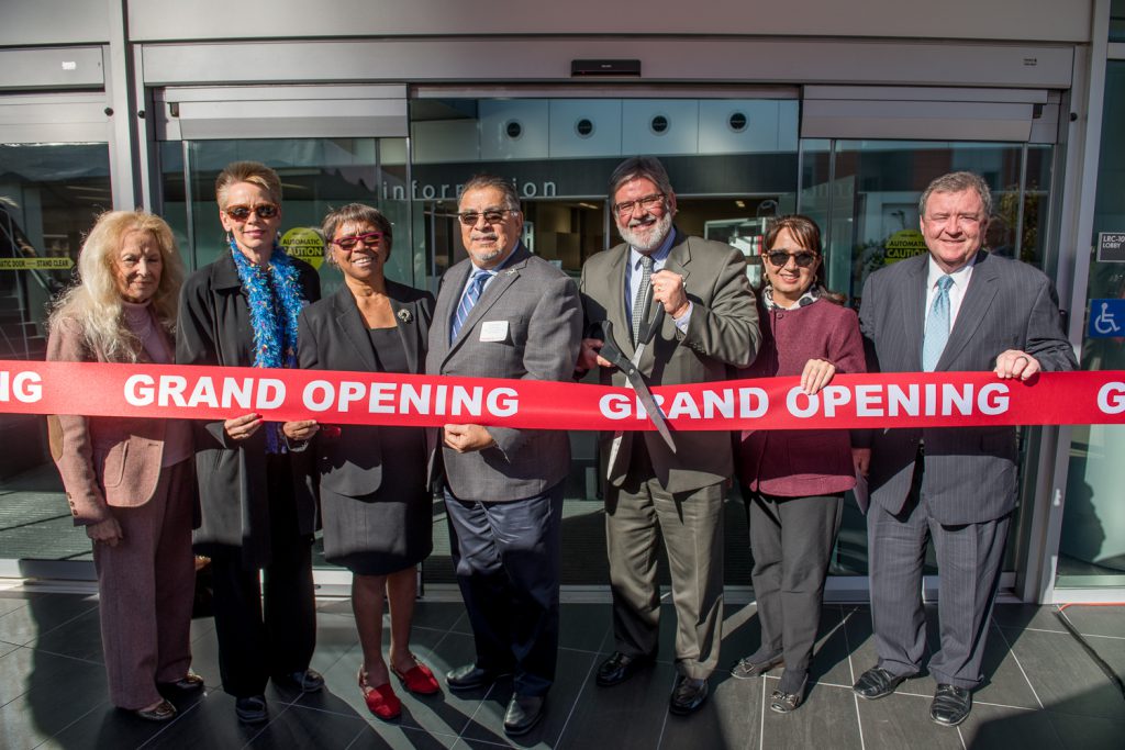 Palomar leadership and staff cutting a red ribbon at the grand opening of the LRC building