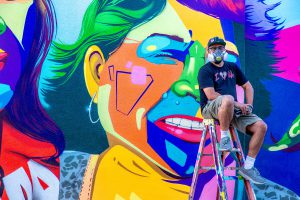 Man One in front of the mural he painted at Palomar College
