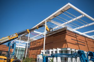 The exterior of the M&O Building having solar panels installed by large cranes
