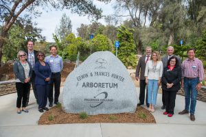 Palomar leadership, staff and guests posed in front of the entrance to the arboretum