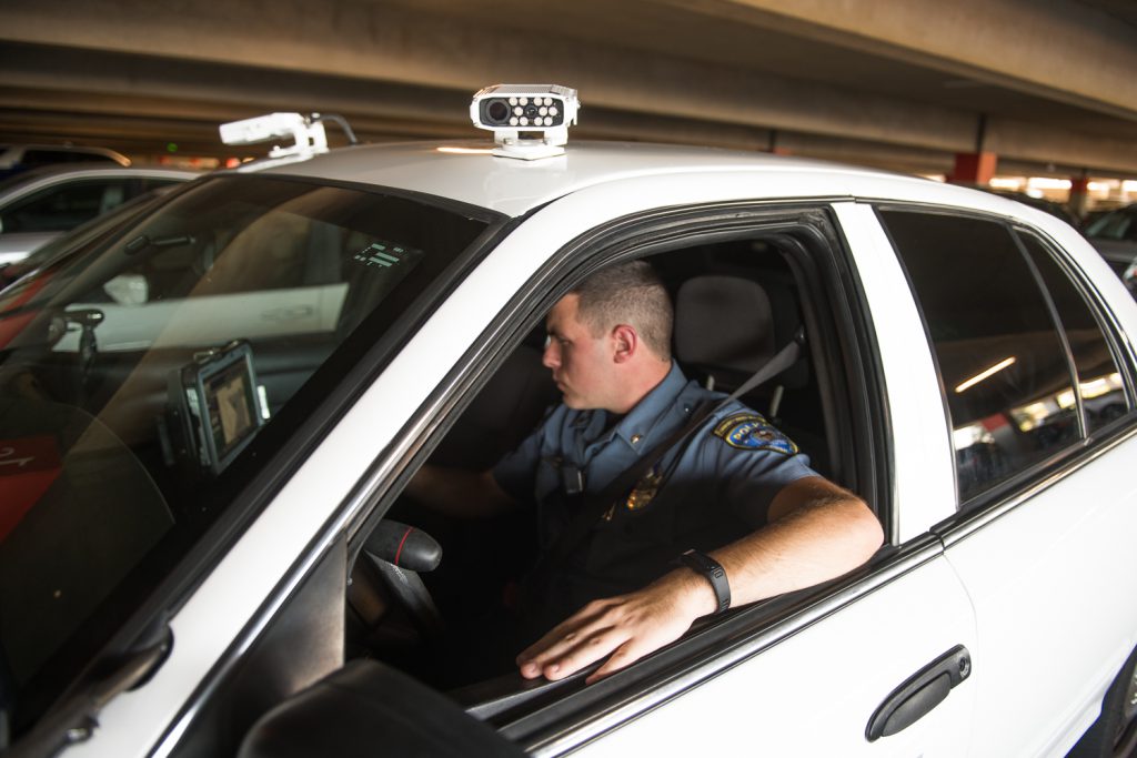 Palomar College Police Department officer in uniform checking parking permits inside cruiser