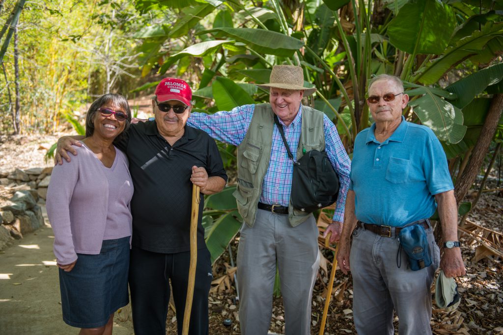 Four people posing in an arboretum