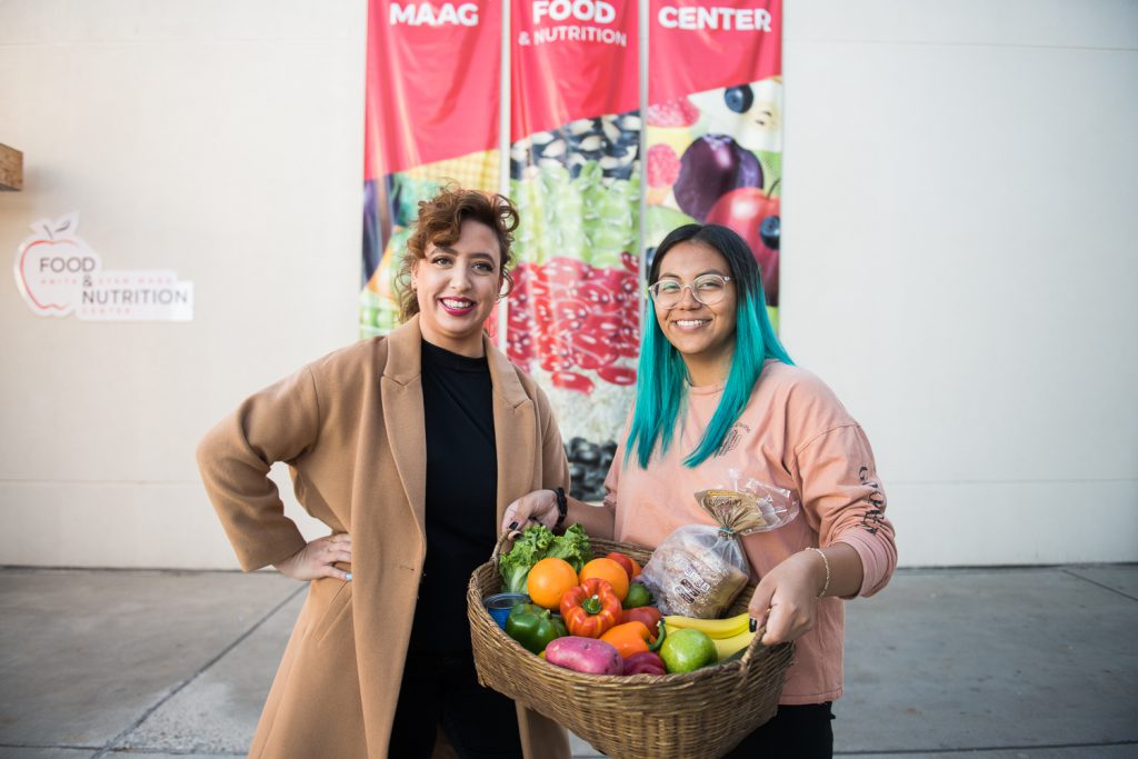 Palomar Associated Student Government members holding a basket of food in front of the Food and Nutrition Center