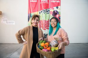 Palomar Associated Student Government members holding a basket of food in front of the Food and Nutrition Center