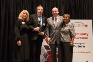 Four Palomar staff members holding an award at the Community Showcase event