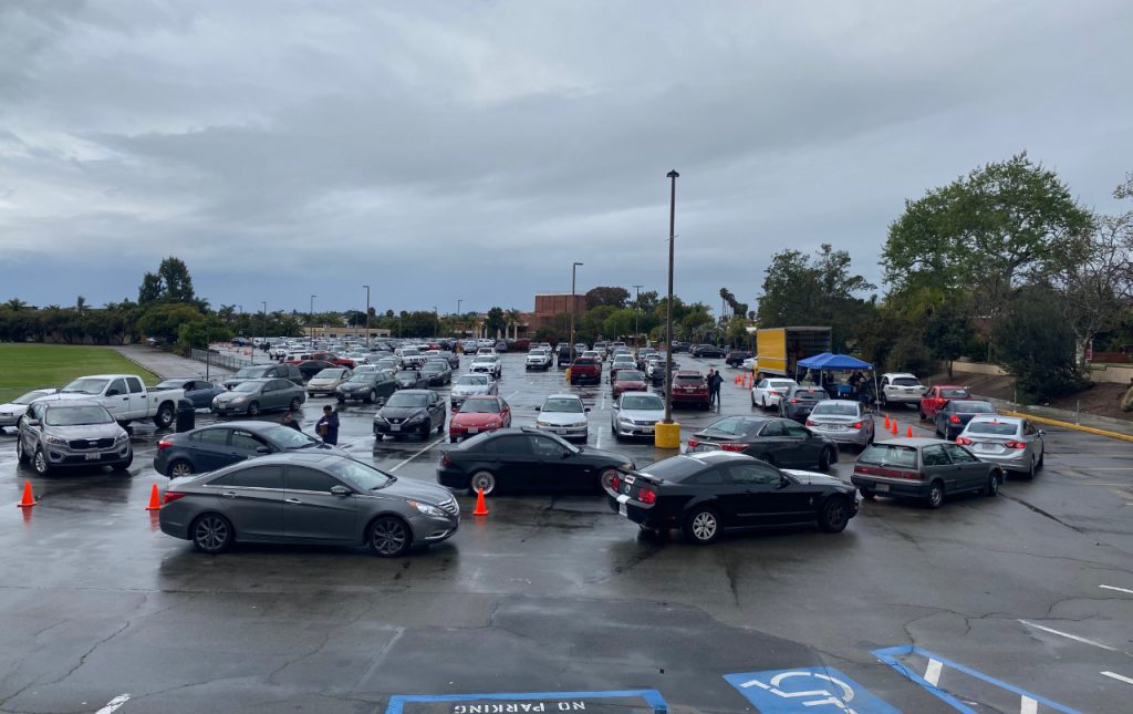 Parking lot line of cars waiting to receive technology distribution