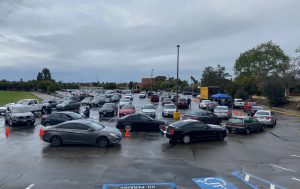 Parking lot line of cars waiting to receive technology distribution