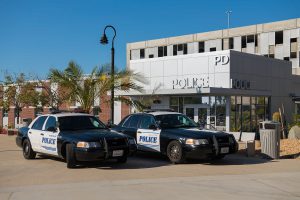 Two police cars in front of the police building on campus