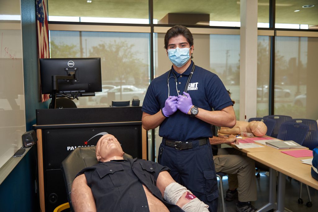 EMT student in classroom with a training dummy
