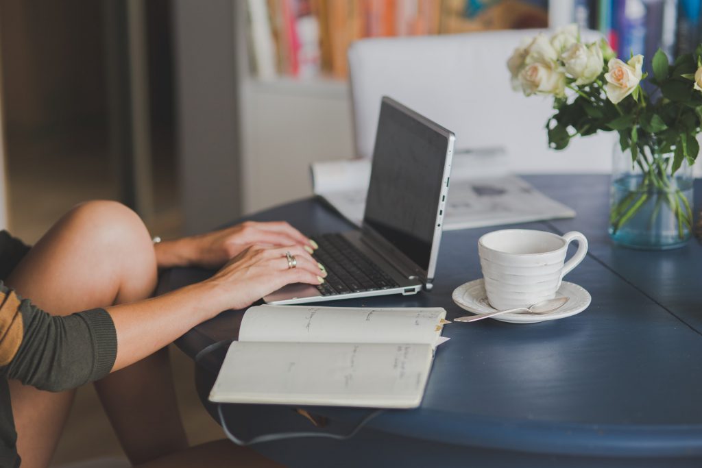 Person sitting at table using a laptop