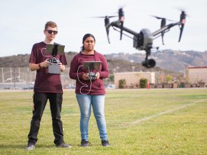 Two students flying a drone on campus