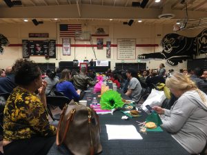 Families sitting at tables in a gymnasium