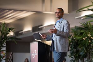 Eugene Whitlock, J.D., speaking at a podium during the Spring 2020 Plenary on campus
