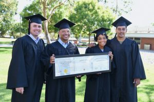 Four MIL Apprenticeship Grads wearing their cap and gowns