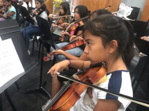 Students playing instruments at the San Marcos Children's Orchestra summer camp at Palomar