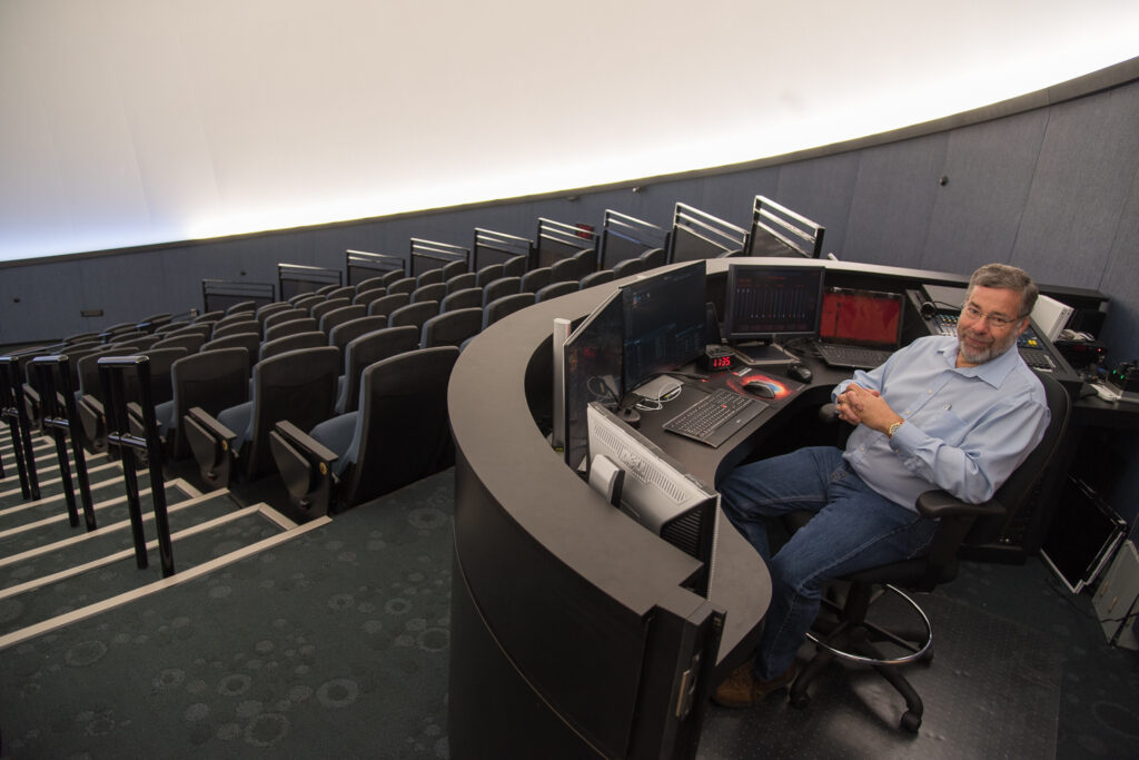 Astronomy professor in the console of a planetarium