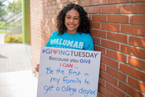 Palomar student holding a sign that reads Giving Tuesday. Because you give I can be the first in my family to get a college degree.