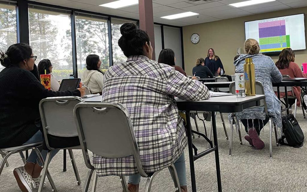Students in a classroom sitting at desks during a lecture
